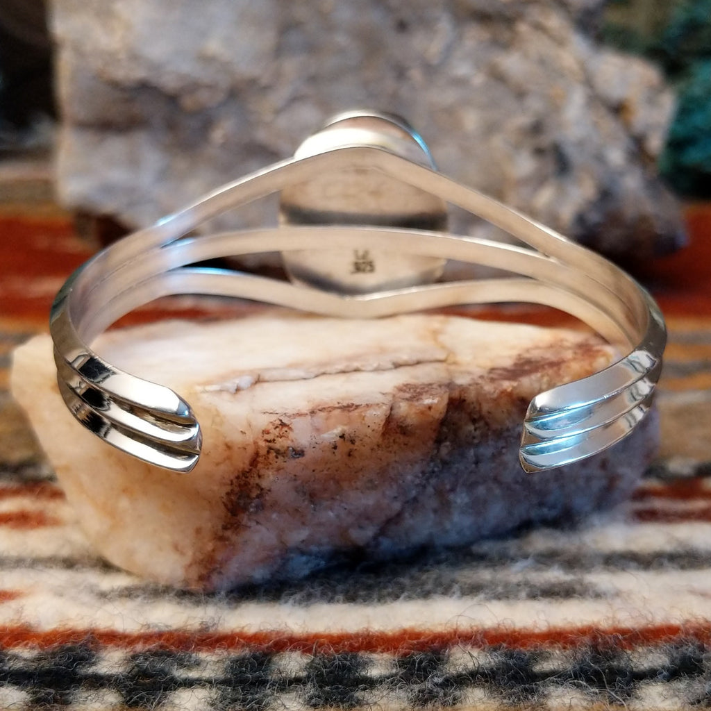 Polished sterling silver band of the cuff.