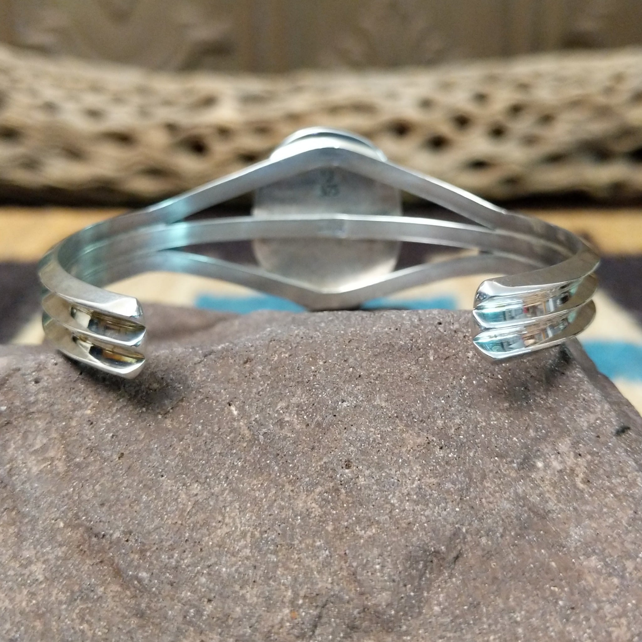 Turquoise Mountain turquoise cuff by Lucy Jake, featuring a blue turquoise stone with a natural brown matrix set in a handcrafted sterling silver cuff; underside view.