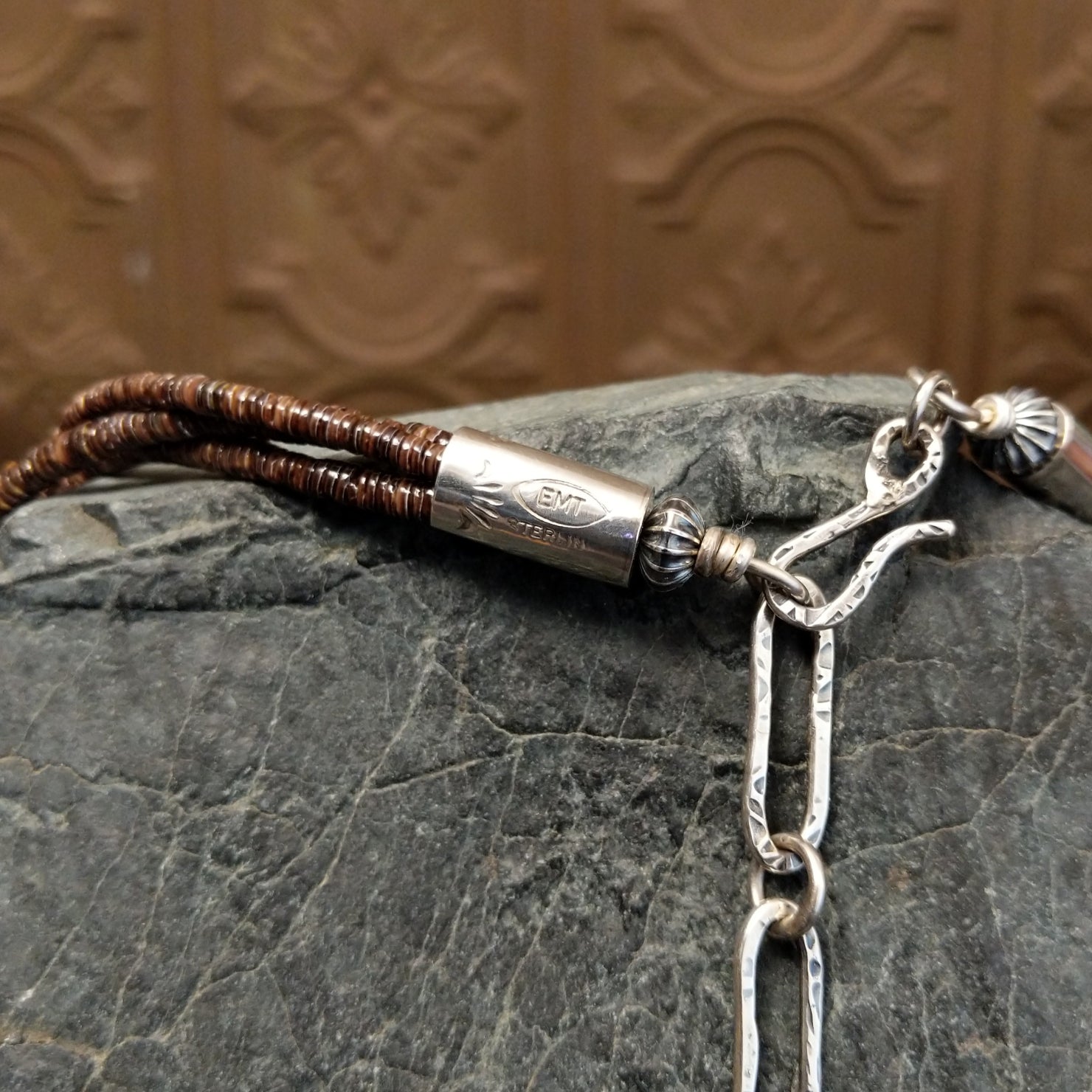 The signature in etched on the sterling silver clasp of the necklace.
