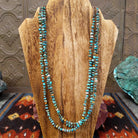 A multi-strand necklace featuring turquoise and orange spiny oyster shell heishi beads, accented with brown pen shell at the sterling silver clasp.