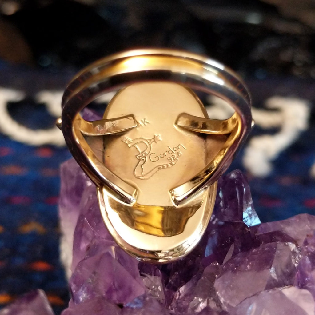 The artist's signature is etched into the inside of the ring.