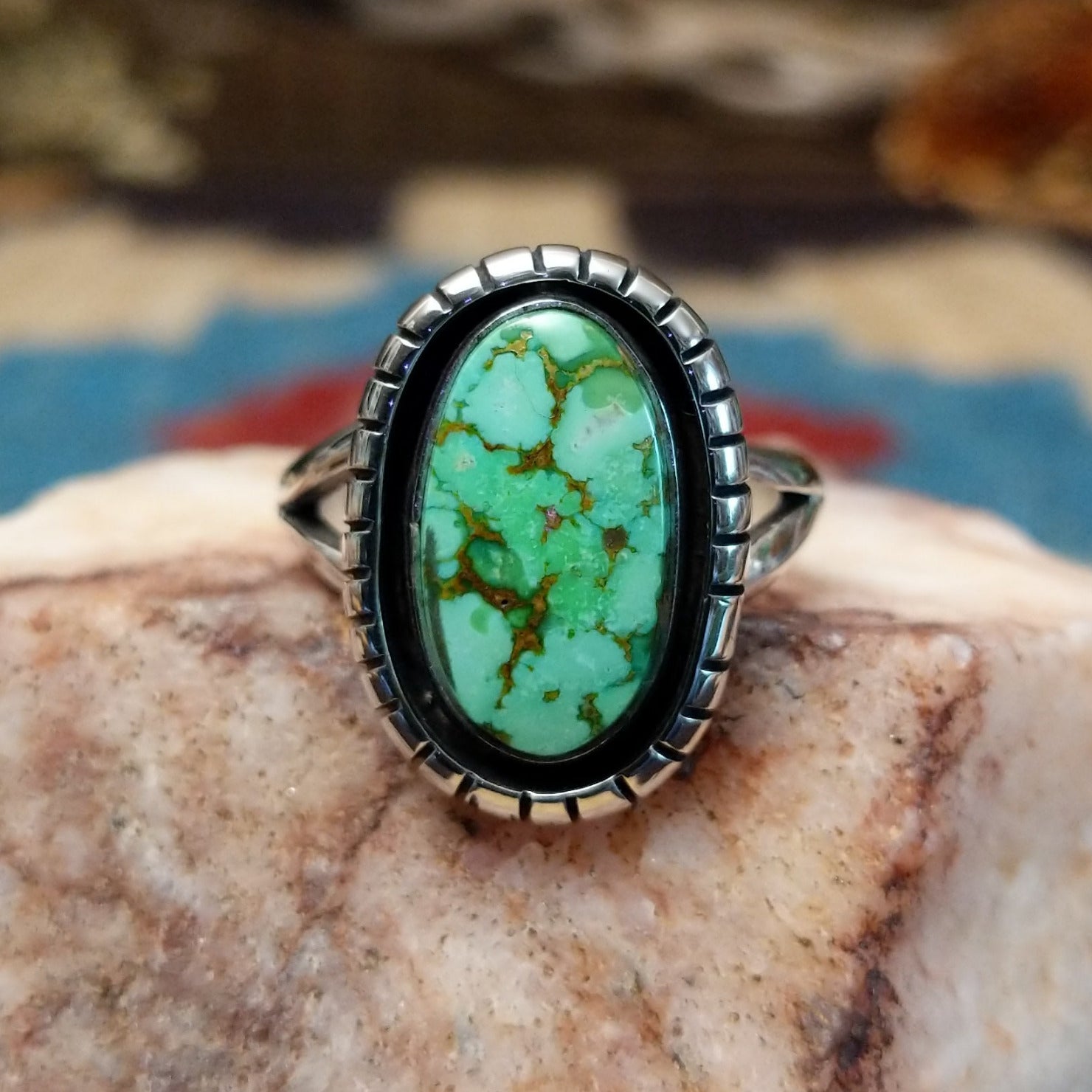 Sterling silver ring with turquoise set in the oval bezel that is framed by the shadowbox setting.