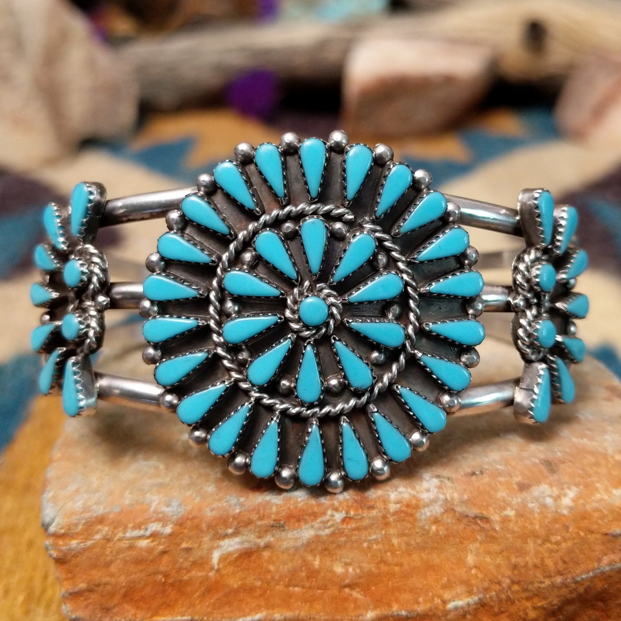 Handcrafted sterling silver cuff by Ray Gasper featuring a large turquoise petitpoint concho  centerpiece with matching side conchos, twisted rope detailing, silver bead accents, and a triple-shank cuff.