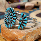 Handcrafted sterling silver cuff by Ray Gasper featuring a large turquoise petitpoint concho centerpiece with matching side conchos, twisted rope detailing, silver bead accents, and a triple-shank cuff; side view.