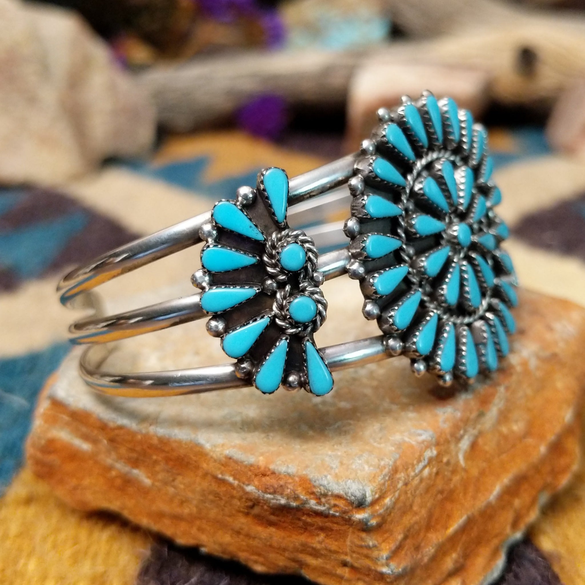 Handcrafted sterling silver cuff by Ray Gasper featuring a large turquoise petitpoint concho centerpiece with matching side conchos, twisted rope detailing, silver bead accents, and a triple-shank cuff; side view.