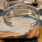 Handcrafted sterling silver cuff by Ray Gasper featuring a large turquoise petitpoint concho centerpiece with matching side conchos, twisted rope detailing, silver bead accents, and a triple-shank cuff; underside view.
