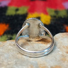 This Turquoise Ring by Byron Begay features a bright blue oval turquoise stone set in sterling silver with a twisted rope border and split-shank band; artisan and Sterling Silver stamp.