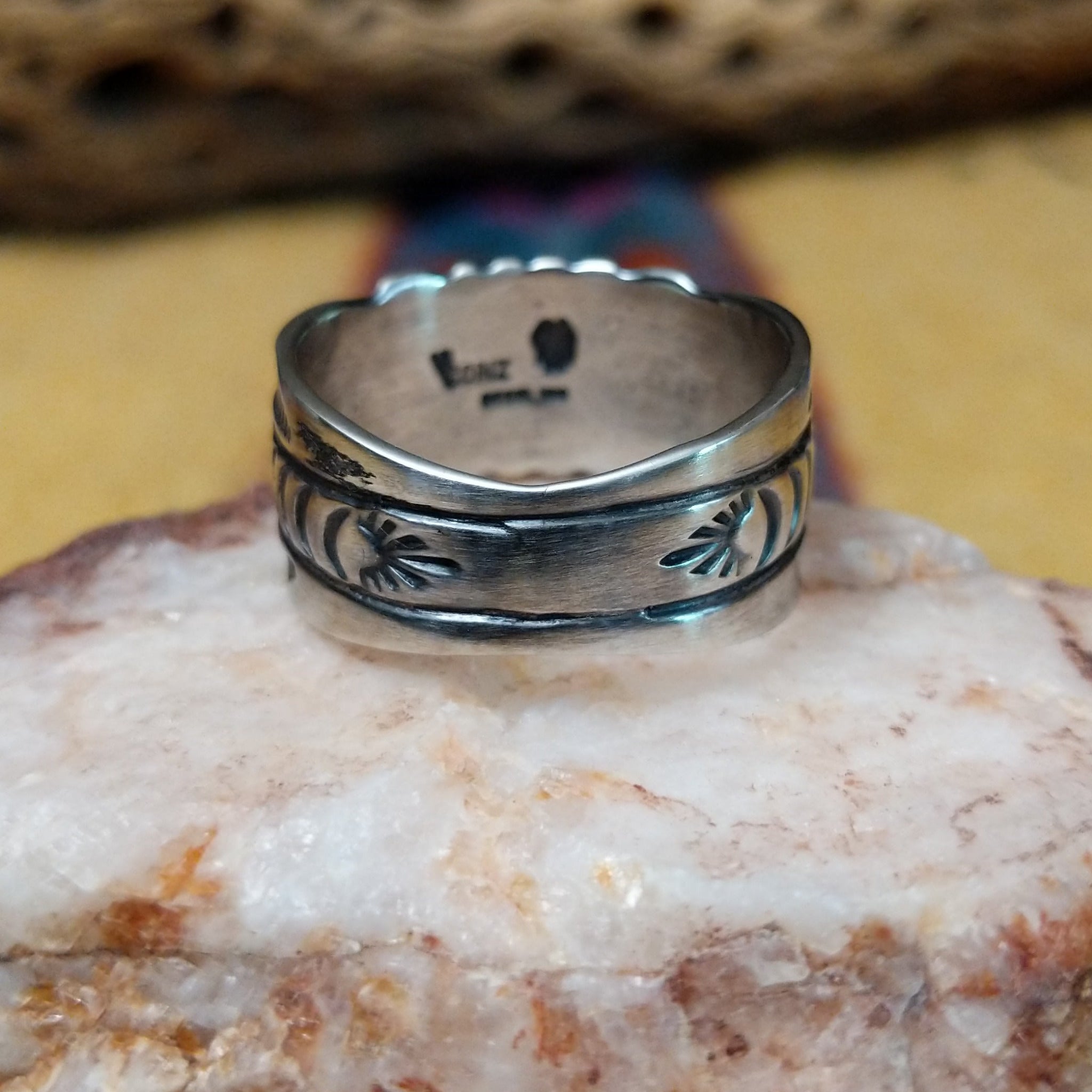 Turquoise round ring by Raymond Coriz, featuring a round turquoise stone set in a handcrafted sterling silver ring with an intricately detailed hand-stamped band.  Underside view.