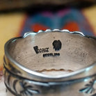 Turquoise round ring by Raymond Coriz, featuring a round turquoise stone set in a handcrafted sterling silver ring with an intricately detailed hand-stamped band.  Artisan and Sterling Silver stamp.