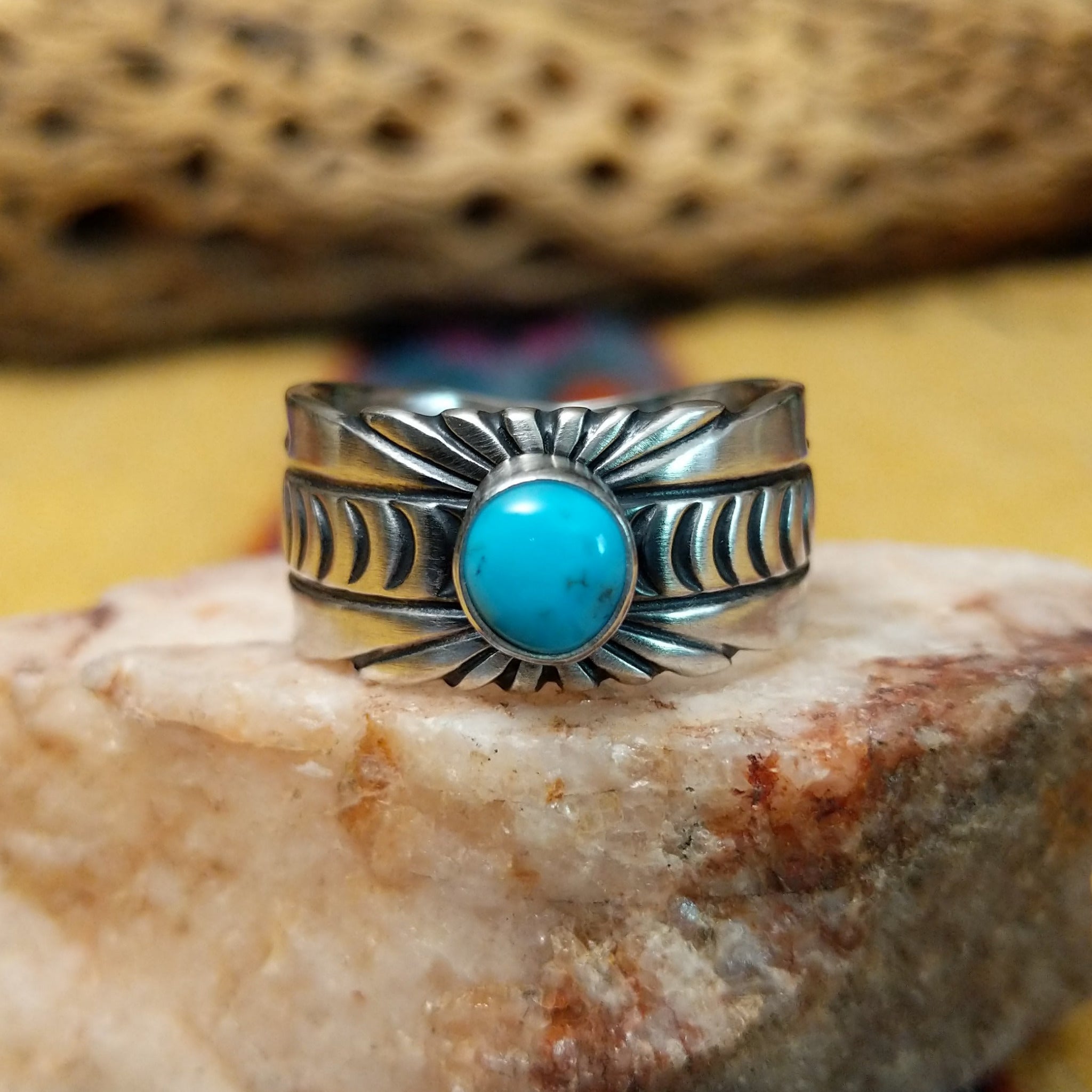 Turquoise round ring by Raymond Coriz, featuring a round turquoise stone set in a handcrafted sterling silver ring with an intricately detailed hand-stamped band.