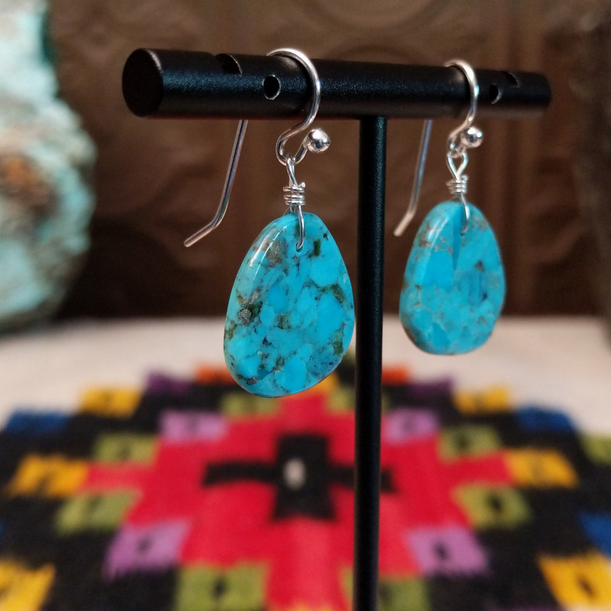 Turquoise Slab Earrings by Ronald Chavez featuring polished freeform blue turquoise stones with natural brown, gray, and green matrix, suspended from simple silver-tone hooks; side view.