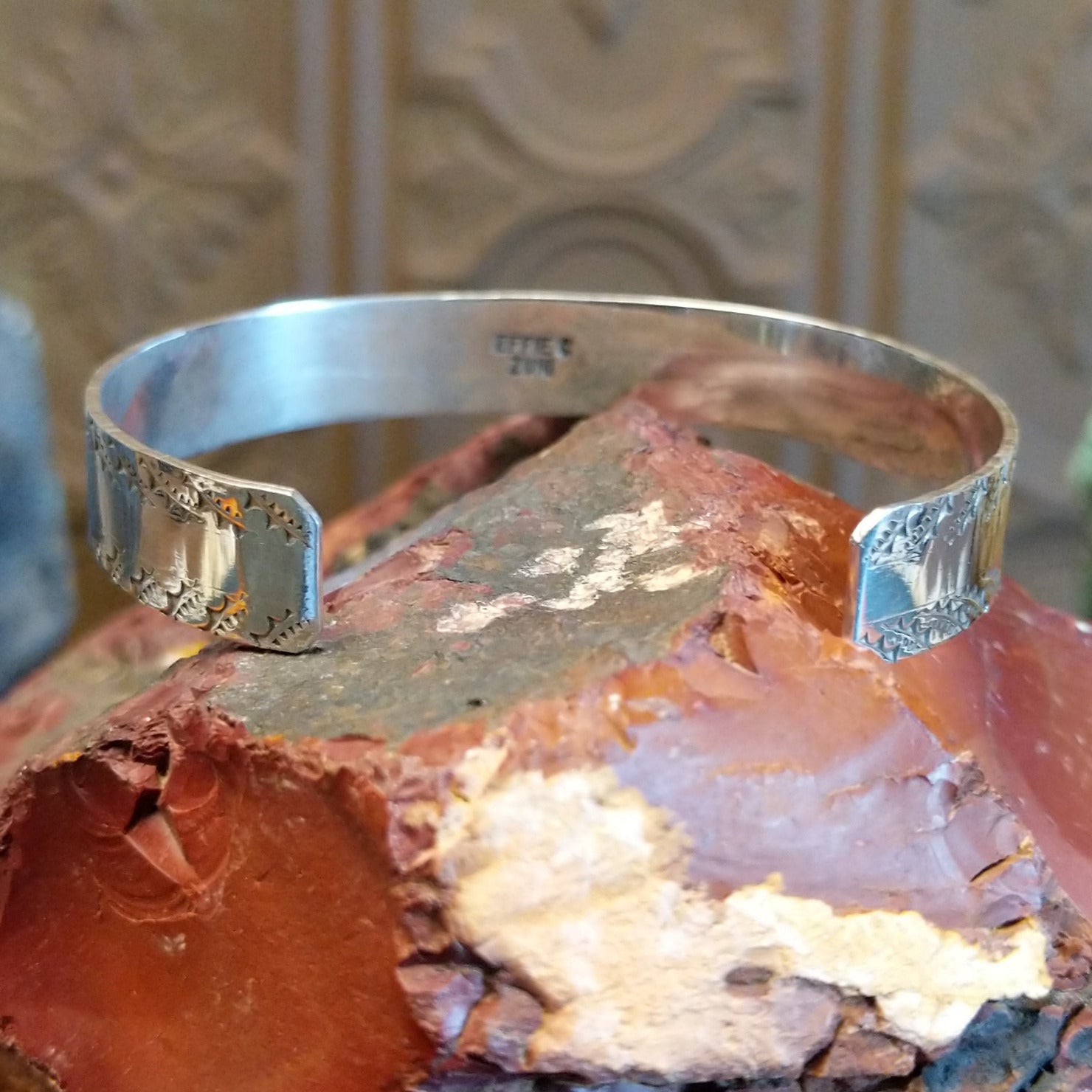Sterling silver cuff bracelet with turquoise set in notched bezels and silverwork formed as a snake along the surface.
