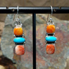 Handcrafted sterling silver turquoise and spiny oyster earrings by the Platero Family, featuring a three-stone dangle design with vibrant orange and blue gemstones.