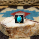 Turquoise square ring by Ann Curley, featuring a vibrant square turquoise stone with natural blue tones and matrix set in a handcrafted sterling silver band.