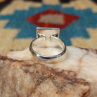 Turquoise square ring by Ann Curley, featuring a vibrant square turquoise stone with natural blue tones and matrix set in a handcrafted sterling silver band.  Underside view.