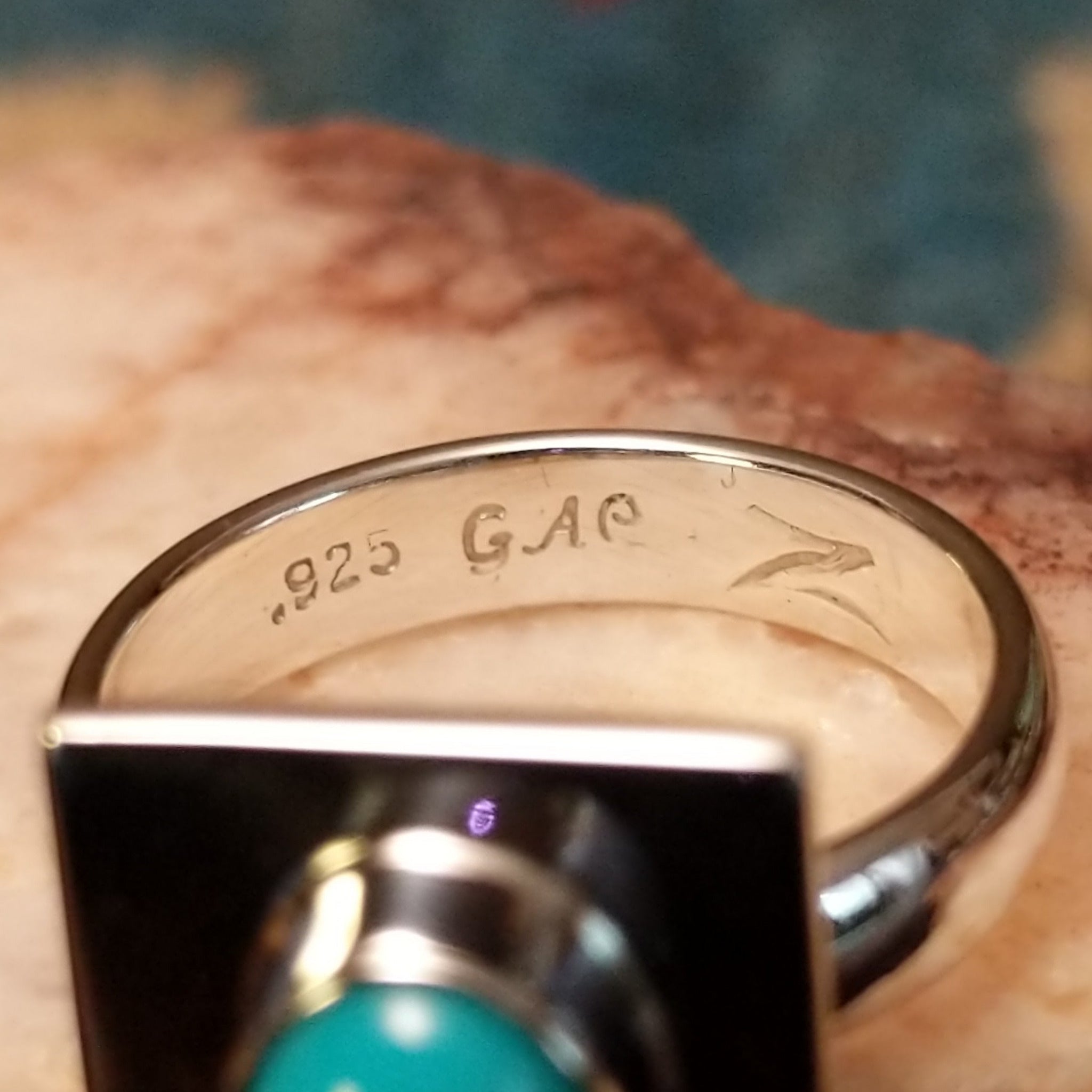 Turquoise square ring by Ann Curley, featuring a vibrant square turquoise stone with natural blue tones and matrix set in a handcrafted sterling silver band.  Artisan and Sterling Silver stamp.