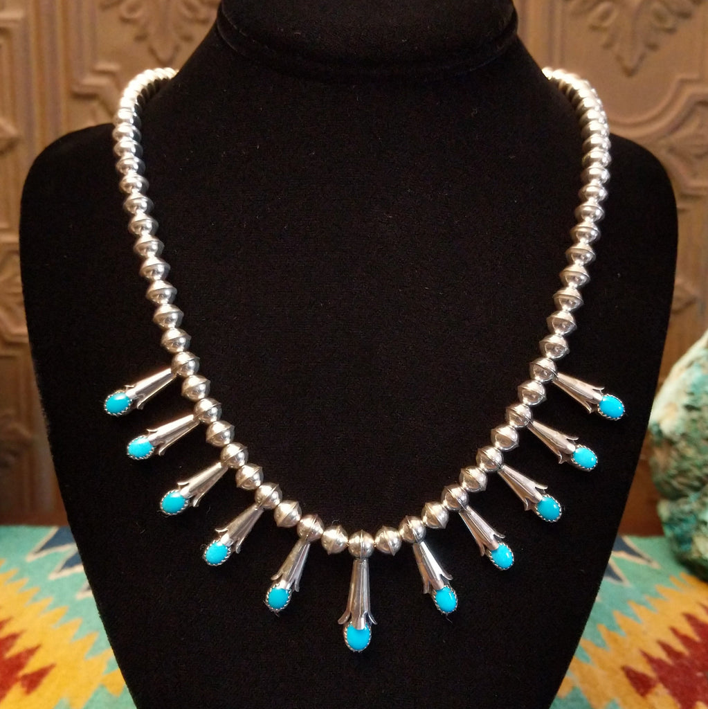 Beaded sterling silver necklace with multiple squash blossom pendants and turquoise set in notched bezels.