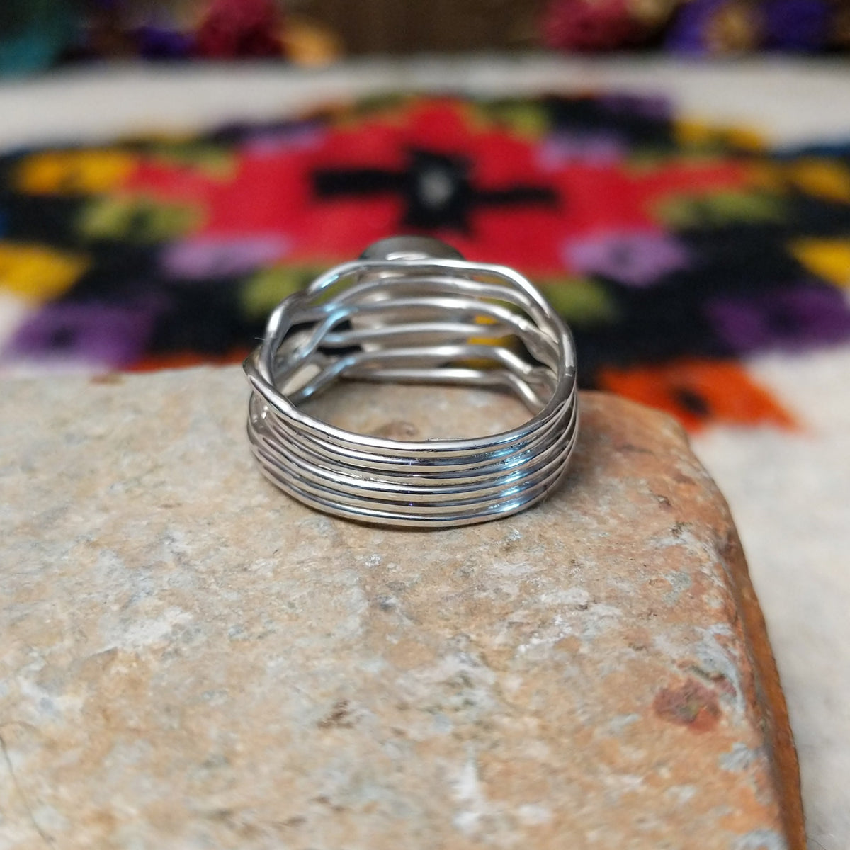 Radiant Turquoise Ring by Angela Martin featuring a round sky-blue turquoise stone set in sterling silver with flowing wave-like silver strands; underside view.
