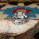Turquoise strand ring by Angela Martin, featuring a round blue turquoise stone set in a handcrafted sterling silver multi-strand band with a polished finish.  Underside view.