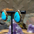 14kt gold Tom Lewis earrings with teardrop turquoise and rope bezel detailing.