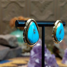 14kt gold Tom Lewis earrings with teardrop turquoise and rope bezel detailing.