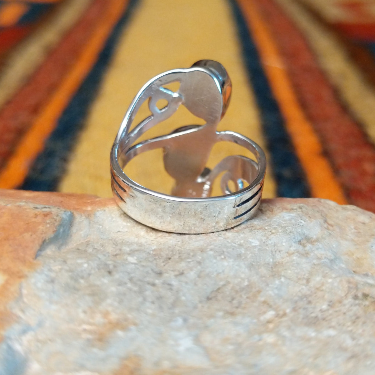 Rear view of a silver turquoise ring by Raymond Coriz showing the openwork band and curled silver accent.