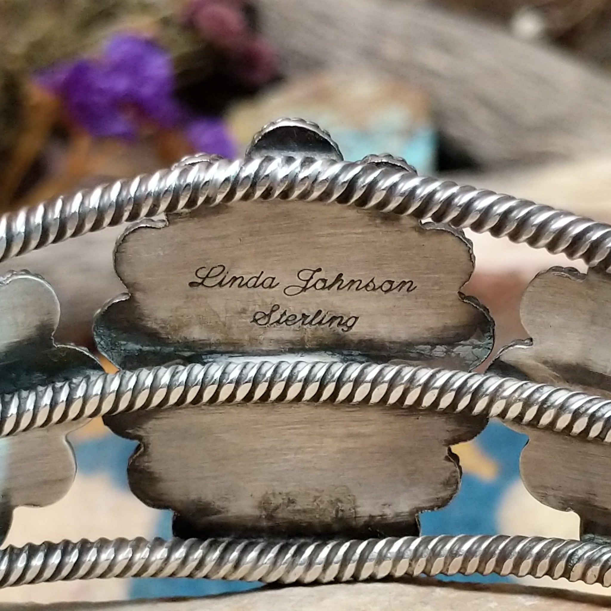 Handcrafted sterling silver cuff by Linda Johnson featuring three vibrant turquoise cabochons with twisted rope bezels, ornate silver beadwork, and a classic double-wire cuff design; artisan and Sterling Silver stamp.