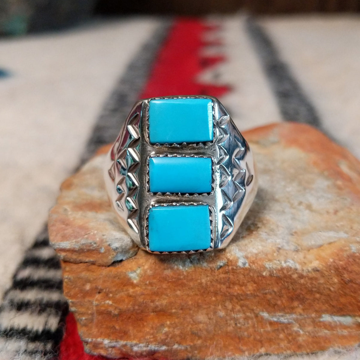 Three-stone turquoise silver ring by Pauline Nelson with stamped details.