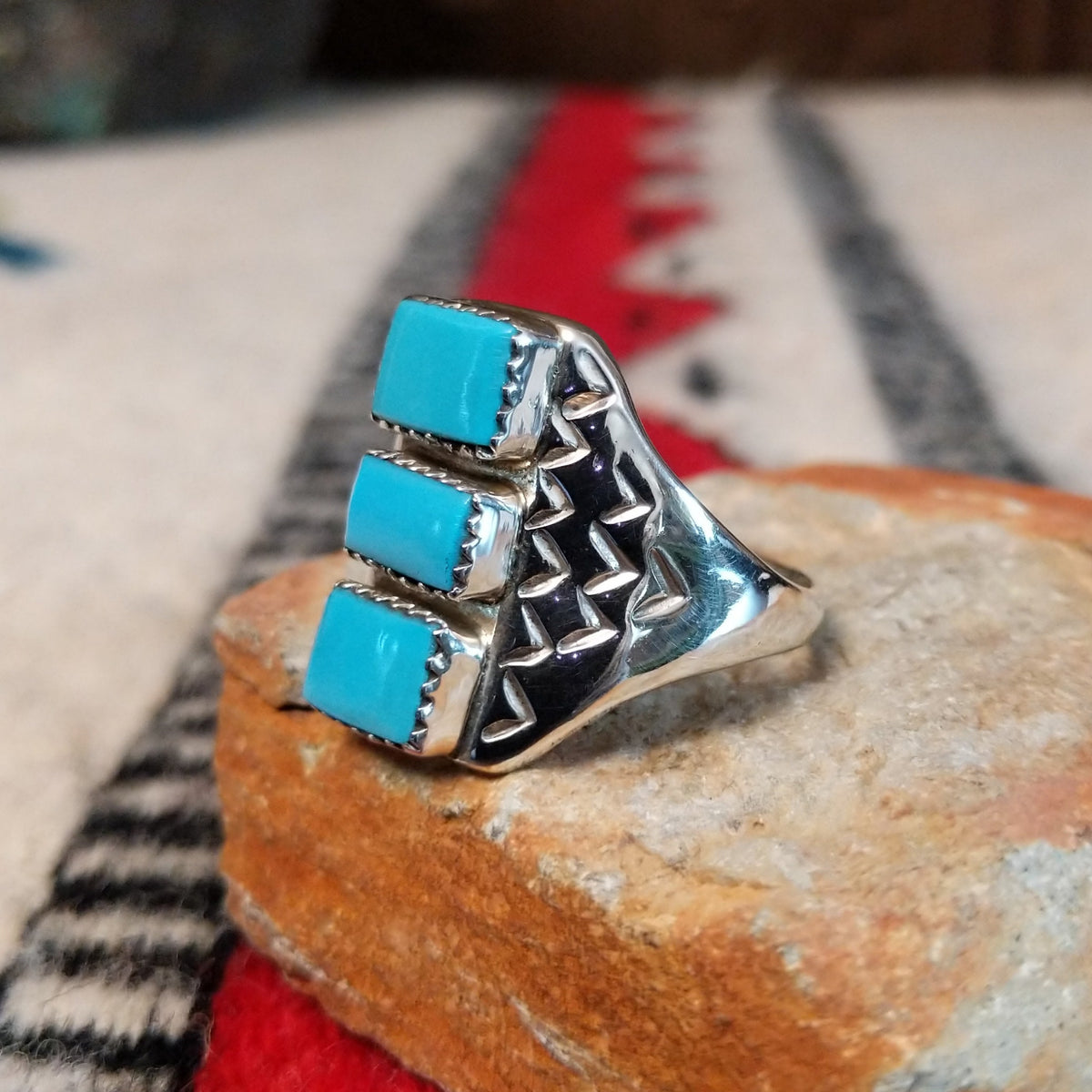 Three-stone turquoise silver ring by Pauline Nelson with stamped details.