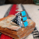 Three-stone turquoise silver ring by Pauline Nelson with stamped details.