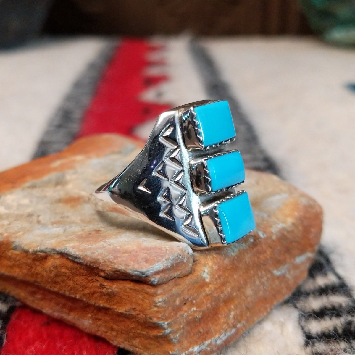 Three-stone turquoise silver ring by Pauline Nelson with stamped details.