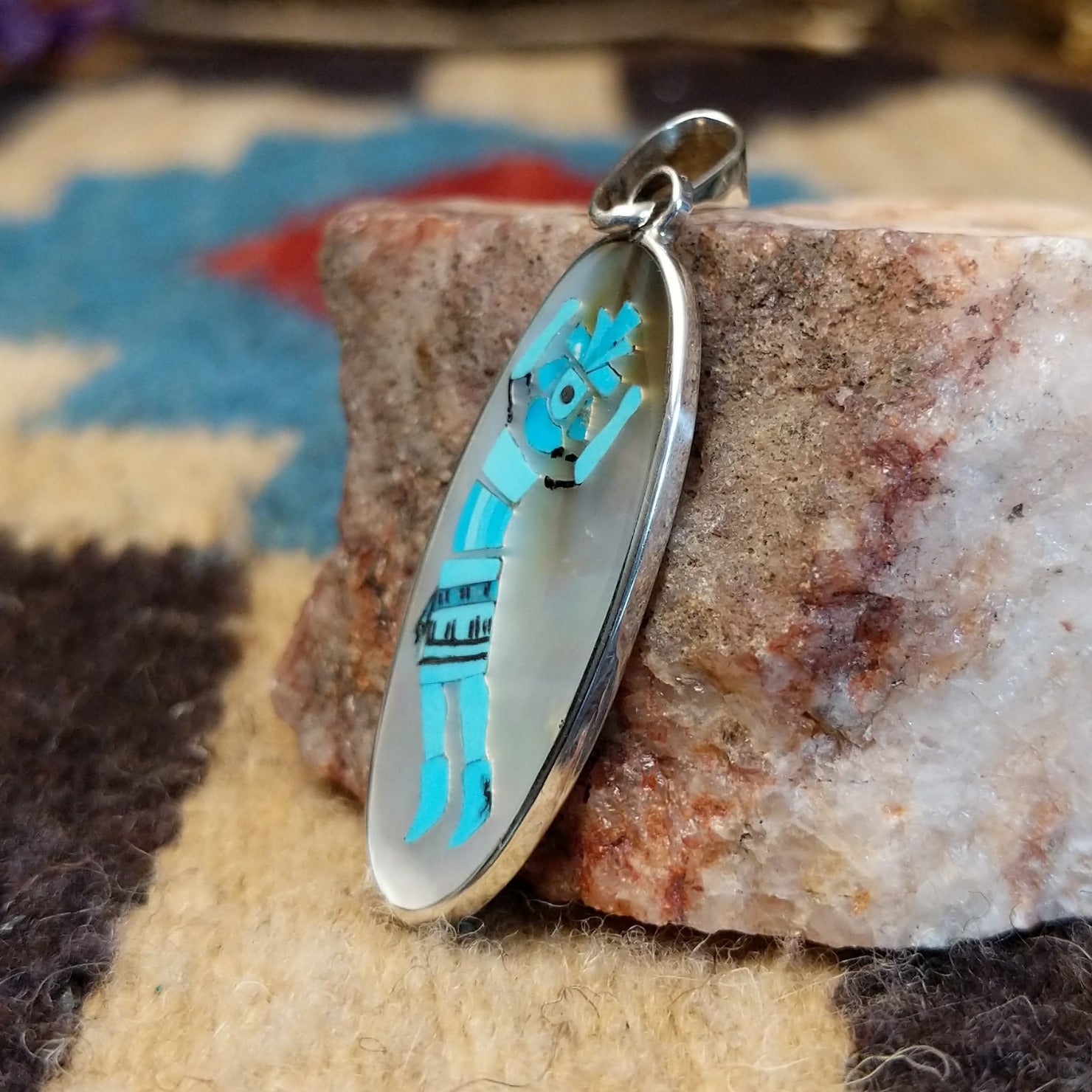 Sterling silver yei pendant featuring mother of pearl and turquoise inlays. 