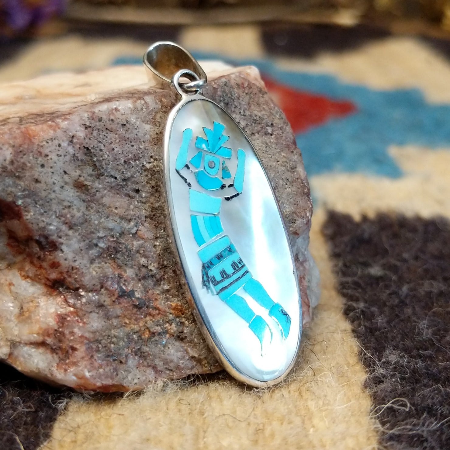 Sterling silver yei pendant featuring mother of pearl and turquoise inlays. 