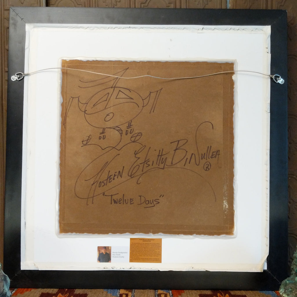 The back features a wire hook and is signed.