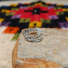 Twisting silver hoop earrings by Caroline Tsosie.