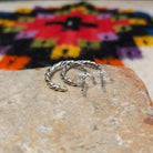 Twisting silver hoop earrings by Caroline Tsosie.