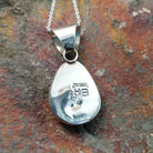 Handcrafted sterling silver turquoise pendant by Elgin Hoskey, featuring a natural blue turquoise stone with brown matrix in a smooth freeform setting; artisan and Sterling Silver stamp.