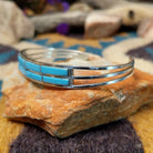 Handcrafted sterling silver two-row cuff by Jamie Johnson featuring vibrant Kingman turquoise channel inlay in a polished, minimalist Native American design; side view.
