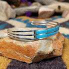 Handcrafted sterling silver two-row cuff by Jamie Johnson featuring vibrant Kingman turquoise channel inlay in a polished, minimalist Native American design; side view.