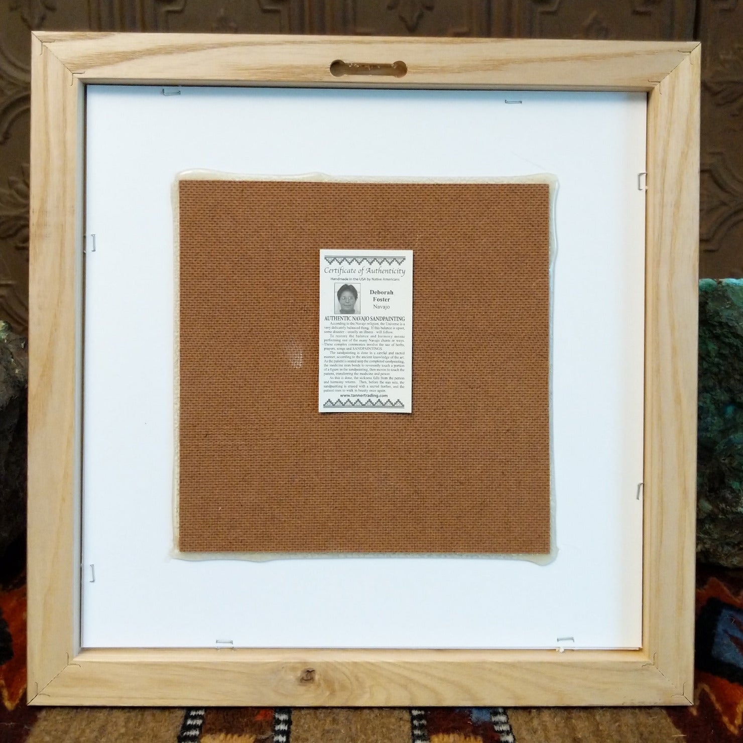 The back of the painting features a place to hang the artwork and the artisan's authentication tag.