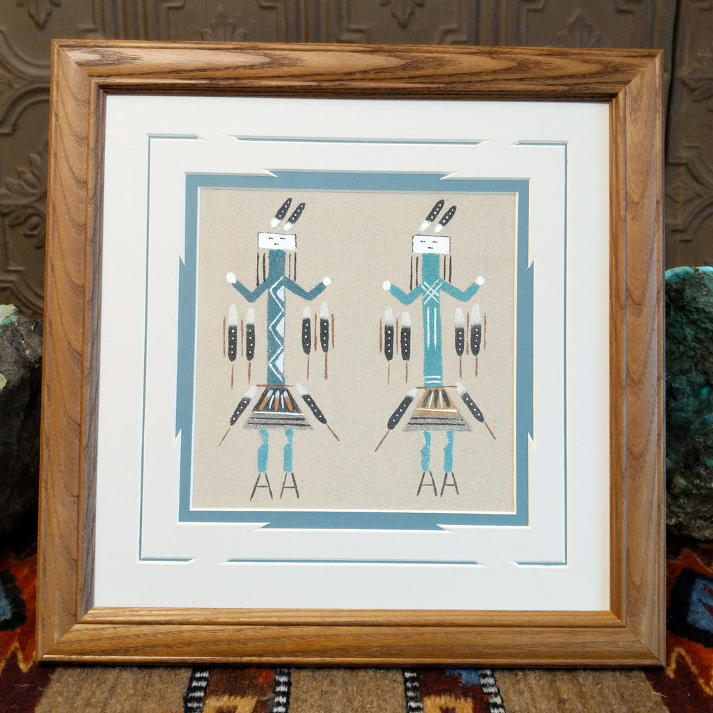 Multiple colored sand depicting two Yei's set within a wooden frame.