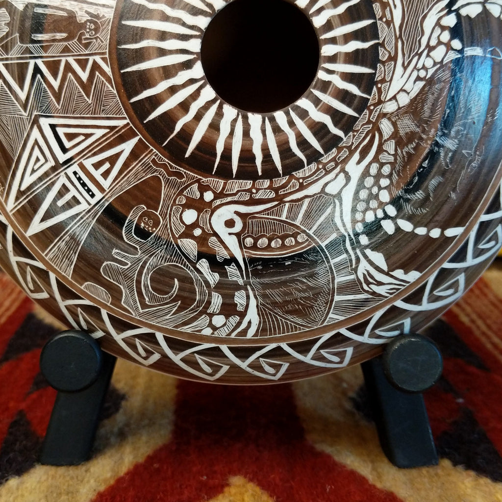 Decorative pottery with intricate white patterns on a dark background