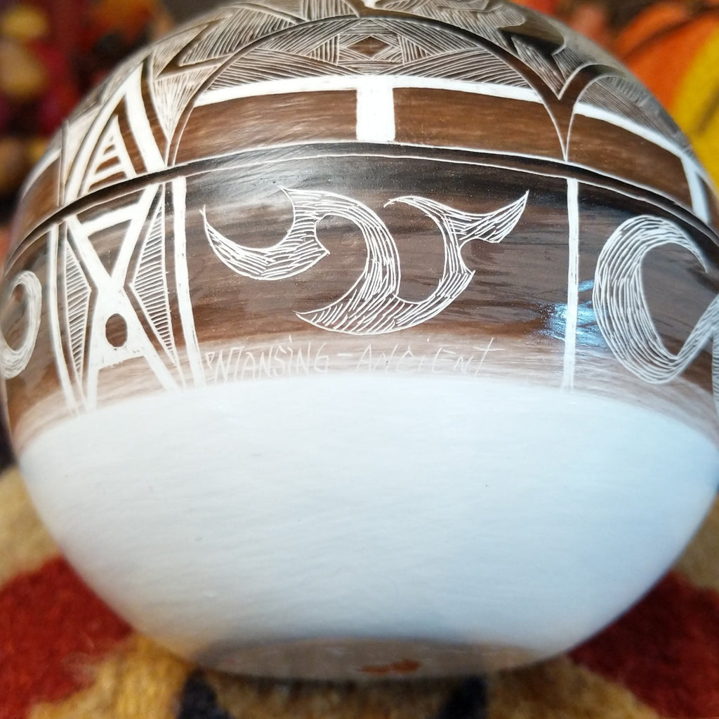 A close-up of the artisan's signature and title of the pottery.