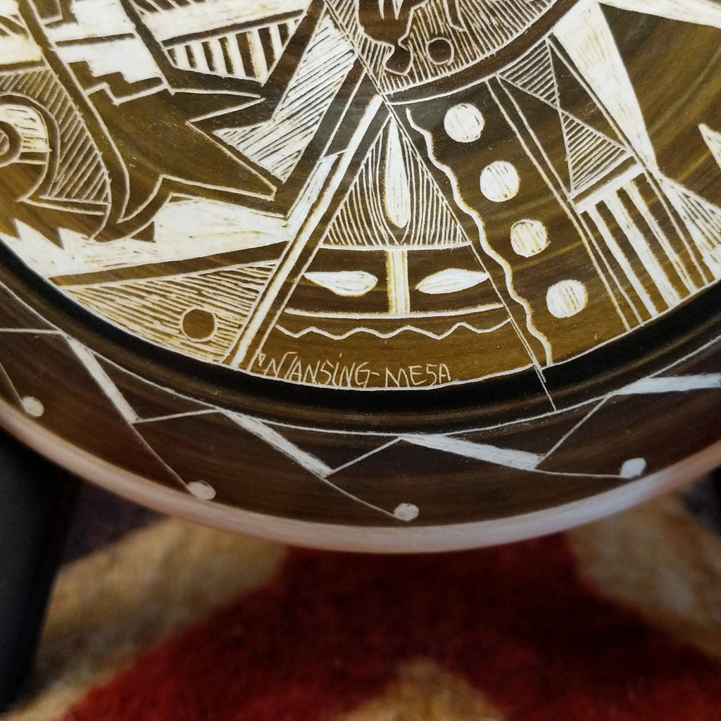 A close-up of the artisan's signature and title of the piece.