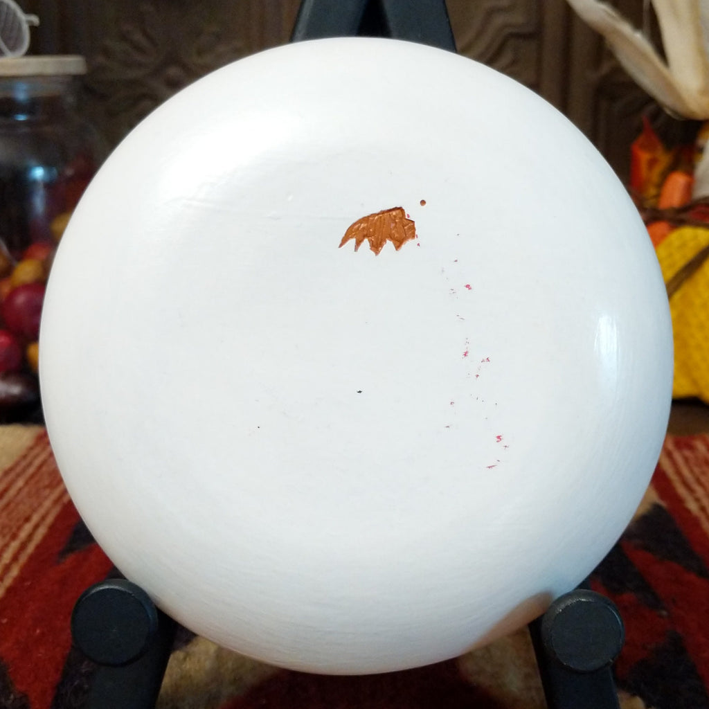 The artisan's trademark is found on the underside of the piece.