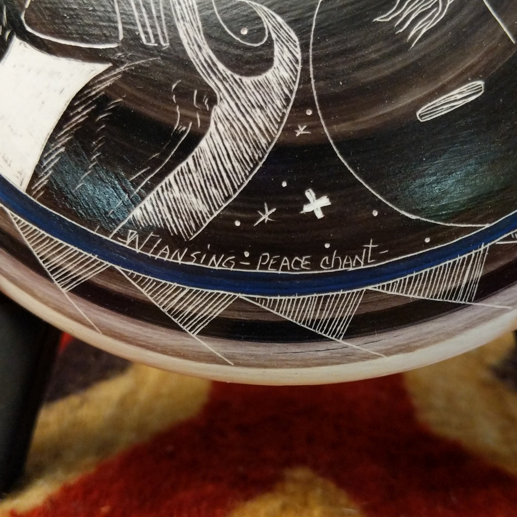 A close-up of the artisan's signature and title of the piece.