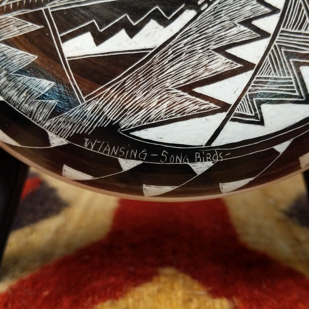 A close-up of the artisan's signature and title of the piece.