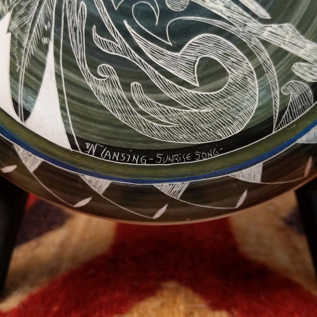 A close-up of the artisan's signature and title of the piece.