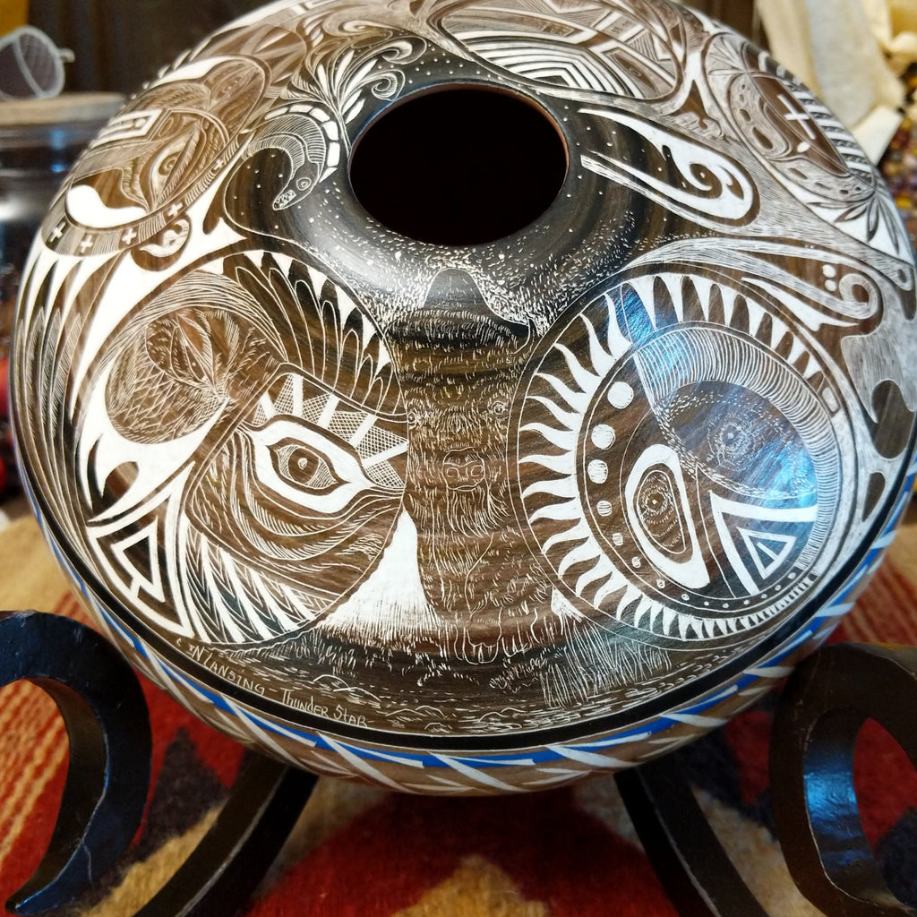 White clay with brown accents carved with detailed eyes and intricate designs.