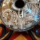 White clay with brown accents carved with detailed eyes and intricate designs.